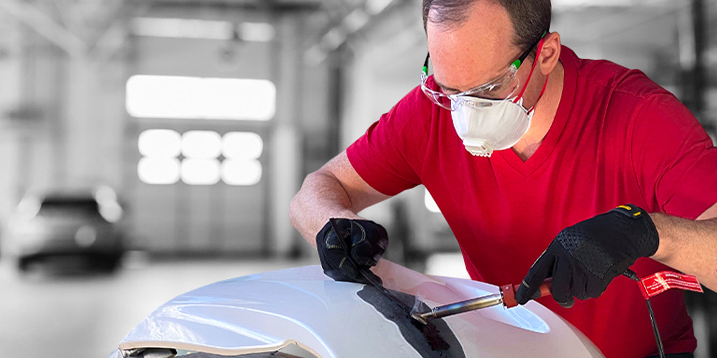Man using plastic welding kit to fix car bumper